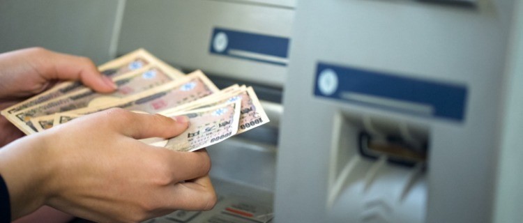 ATMで借入れ金額を返済する女性